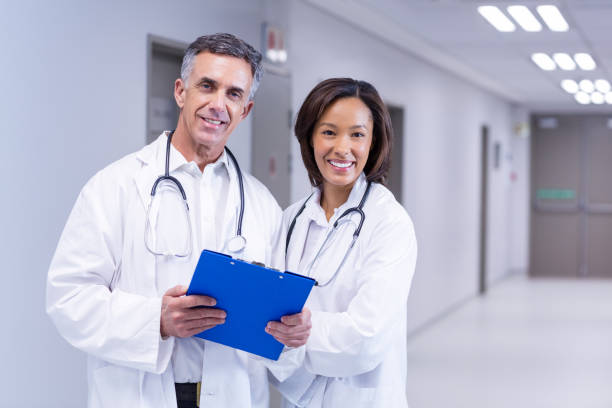 istock Portrait of smiling doctors standing in corridor 653872498