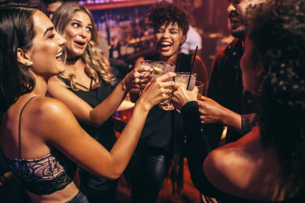 Group of friends partying in a nightclub Group of friends partying in a nightclub and toasting drinks. Happy young people with cocktails at pub. nightlife stock pictures, royalty-free photos & images