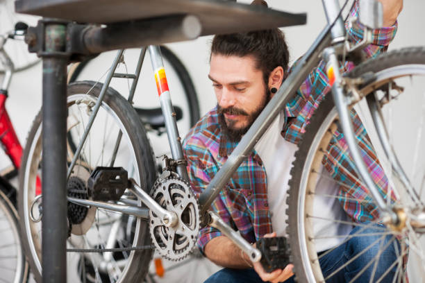 istock Repairman repairing bicycle in workshop 653872934