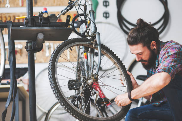 istock Repairman repairing bicycle in workshop 653873018