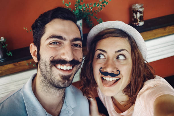istock Couple in a bar gesturing for selfie 653873330