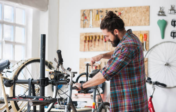 istock Repairman repairing bicycle in workshop 653874148