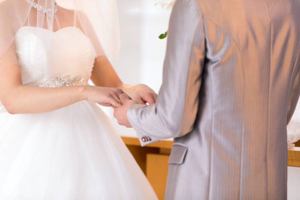 Happy bride and groom exchaning wedding ring in chapel