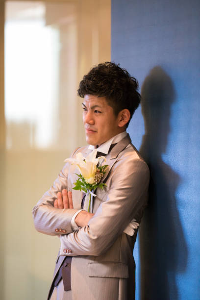 istock Japanese groom leaning on wall with confidence 653874624