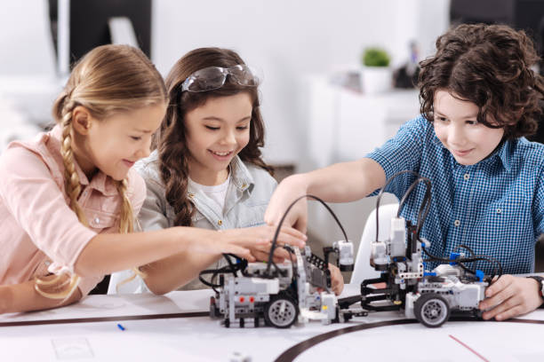 istock Cheerful kids working on the tech project at school 653874736