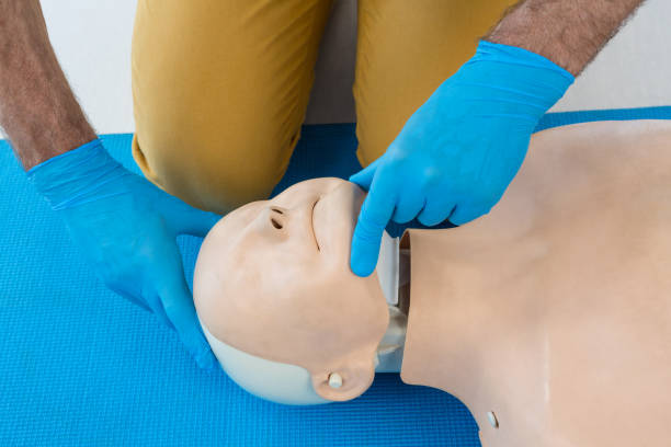istock Mid section of paramedic practising resuscitation on dummy 653874932