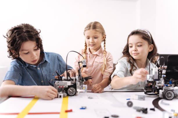 istock Joyful little friends working on the tech project at school 653874946