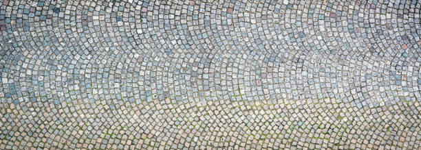 Patterned cobble background photographed from directly above A background texture of cobbles in Paris, France. cobblestone stock pictures, royalty-free photos & images