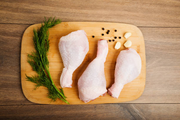 istock raw chicken legs on wooden board 653878524