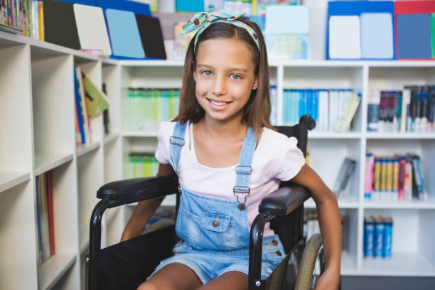 istock Disabled smiling schoolgirl in library 653880720