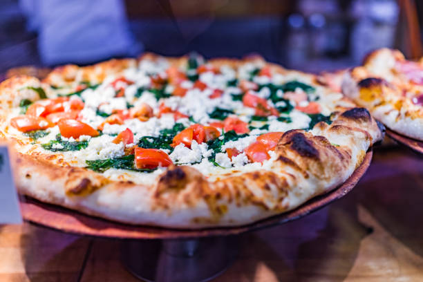 istock Feta cheese pizza macro closeup with tomatoes and spinach 653883272