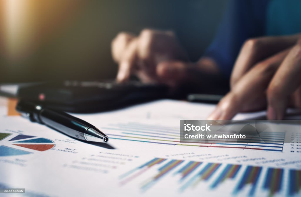 Close up pen on paperwork and woman hand calculate finance. Examining Stock Photo