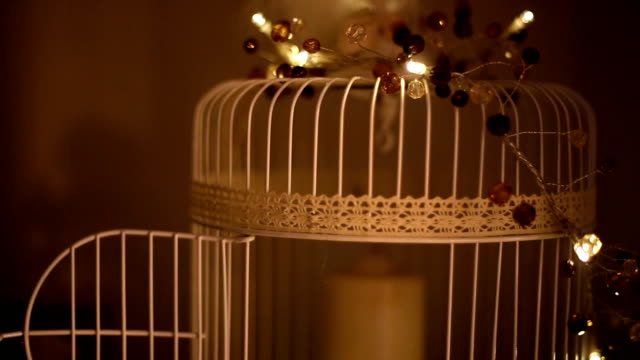 decorative cage with a candle on a wooden background.Monochrome