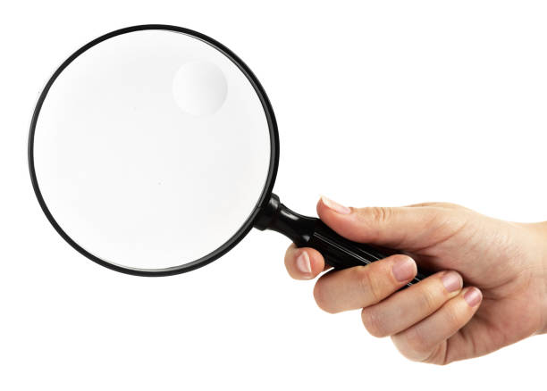 istock Hand holding magnifying glass over white background. 653893614