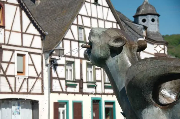 Tatzelwurm fountain statue with an old half-timbered house in Kobern-Gondorf, Germany