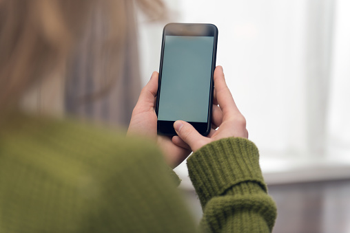 The device screen is left empty for your own telephone web page design or photograph. The photo was taken over the model's shoulder out of a rear view.