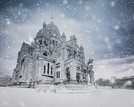 The Basilica of the Sacred Heart (Sacré-Cœur Basilica) during a snow storm in February 2013. Montmartre, Paris, France. Commonly known as Sacré-Cœur Basilica and often simply Sacré-Cœur (French: Basilique du Sacré-Cœur), is a Roman Catholic church and minor basilica, dedicated to the Sacred Heart of Jesus, in Paris, France. A popular landmark, the basilica is located at the summit of the butte Montmartre, the highest point in the city. Sacré-Cœur is a double monument, political and cultural, both a national penance for the defeat of France in the 1871 Franco-Prussian War and the socialist Paris Commune of 1871 crowning its most rebellious neighborhood, and an embodiment of conservative moral order, publicly dedicated to the Sacred Heart of Jesus, which was an increasingly popular vision of a loving and sympathetic Christ.

