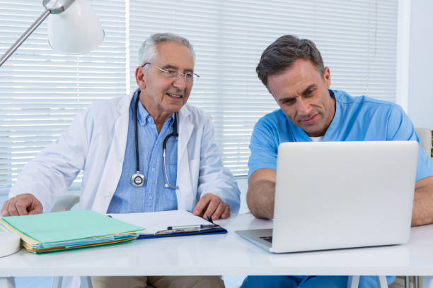 istock Surgeon and doctor discussing over laptop 653902786