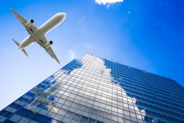 istock Skyscrapers with a flying airplane against blue sky 653904052