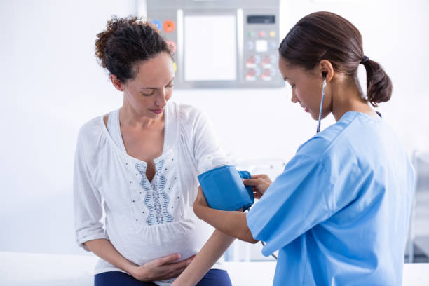 врач проверяет артериальное давление беременной женщины - prenatal care стоковые фото и изображения