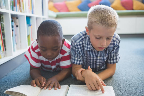 istock School kids reading book in library 653909710