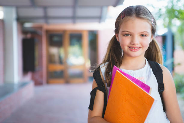 istock Happy schoolkid standing in corridor 653910728