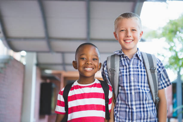 istock Smiling schoolkids standing in corridor 653910824