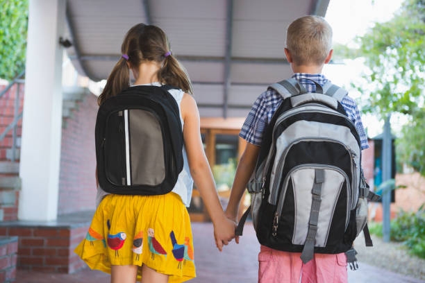 istock Rear view of schoolkids standing in corridor 653911044