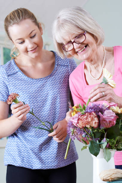 istock Senior Woman With Teacher In Flower Arranging Class 653912084