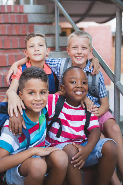 istock Smiling schoolkids sitting on staircase at school 653912472