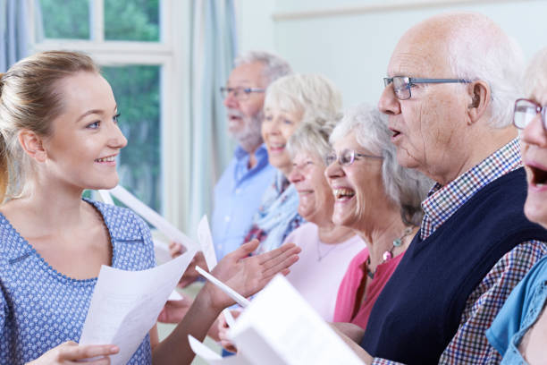 grupa seniorów z nauczycielem śpiewu w chórze razem - singing lesson zdjęcia i obrazy z banku zdjęć