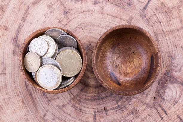 istock Coins in wooden bowl 653926712