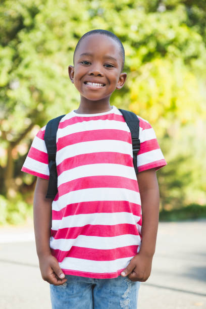 istock Happy schoolboy standing in campus 653927216