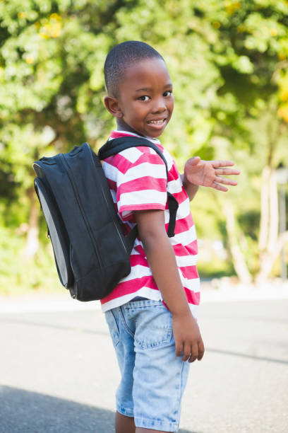 istock Happy schoolkid waving hand in campus 653927228