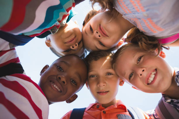 istock Schoolkids forming huddle in campus 653927602
