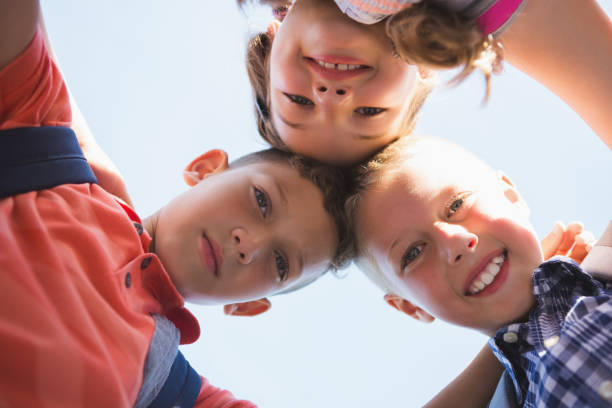 istock Schoolkids forming huddle in campus 653927666