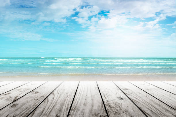 istock old wood table top on blurred beach background. 653928368