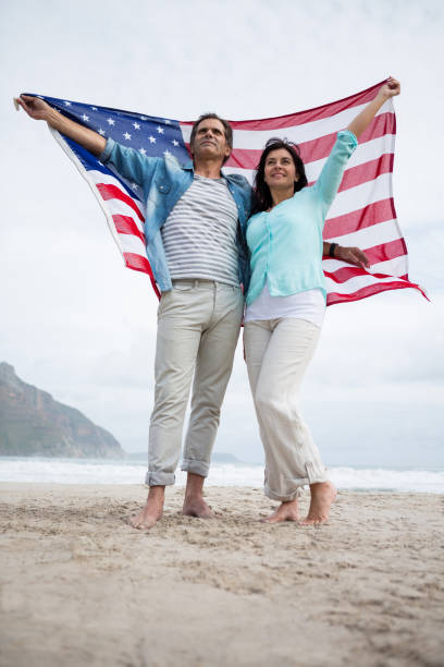 istock Couple holding american flag on beach 653932044