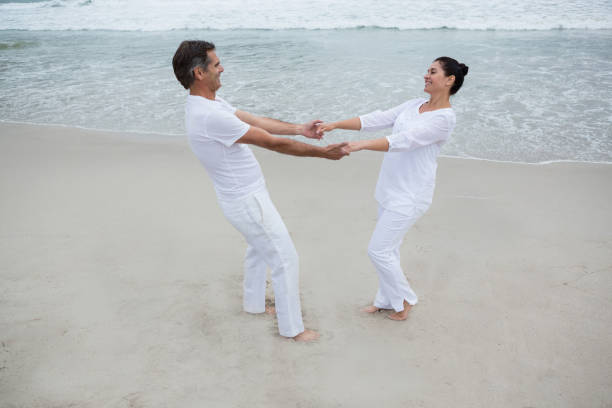istock Romantic couple holding hands on beach 653941532