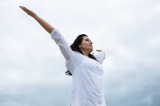 istock Happy woman standing with arms outstretched 653941604