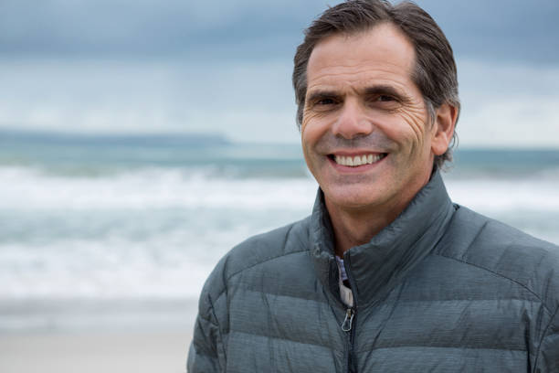 istock Portrait of smiling man on beach 653941738