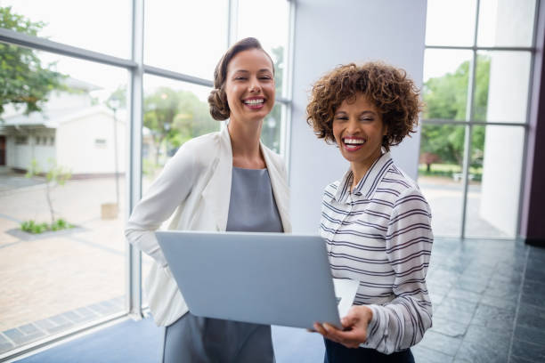 istock Cheerful business executives holding laptop 653941810