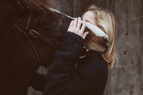 istock Young woman with dark horse 653942004