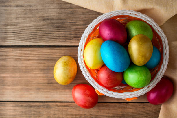 istock Colorful painted easter eggs in basket on rustic wooden table. 653942894