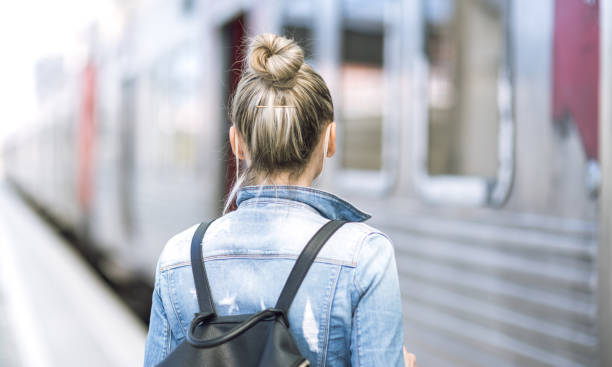 istock Woman traveler with backpack on rail station checking time 653943300