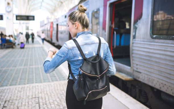 istock Woman traveler with backpack on rail station checking time 653943316