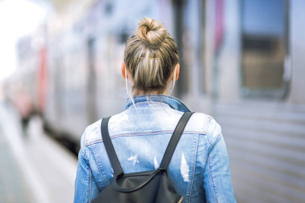 istock Woman traveler with backpack on rail station checking time 653943516