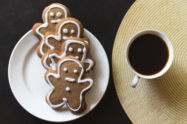 istock gingerbread men on a white plate on black background with a cup coffee 653945840