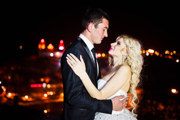 istock Gorgeous wedding couple background night city with castle in light 653946722