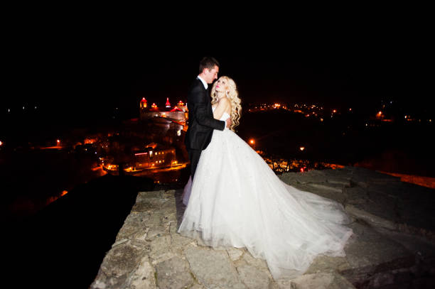 istock Gorgeous wedding couple background night city with castle in light 653946798